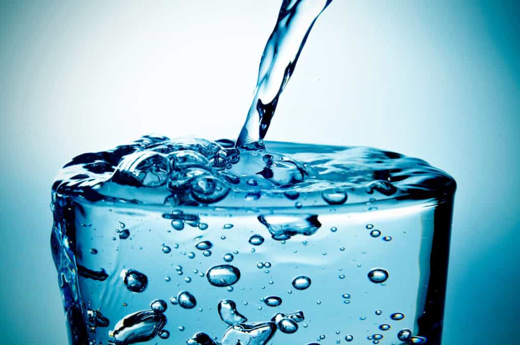 Water pouring into a clear glass.
