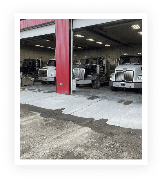 Several trucks parked inside a garage.