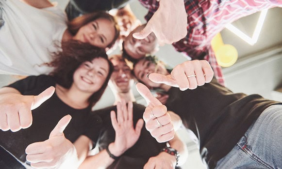 Group of people showing thumbs up together.
