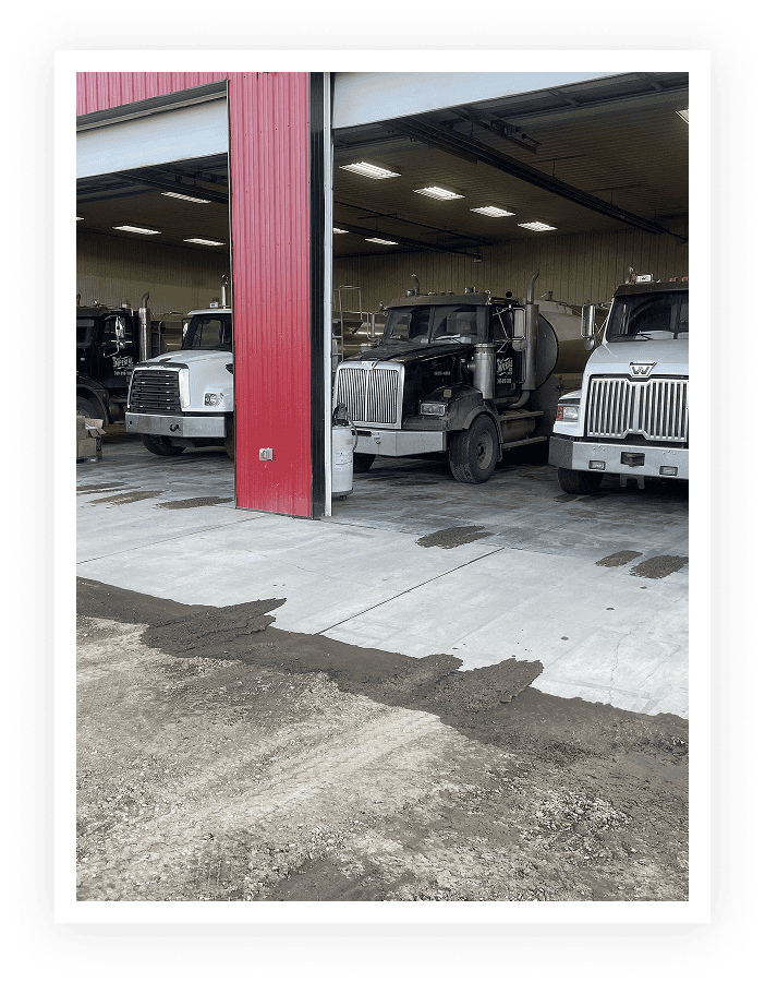 Trucks parked in a garage with red walls.