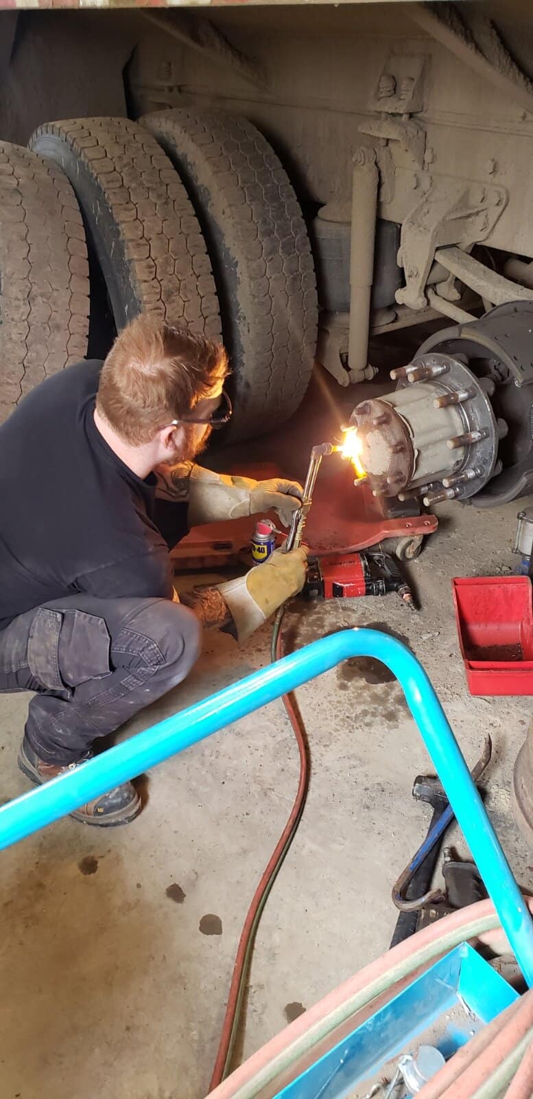 A mechanic repairing equipment with a torch