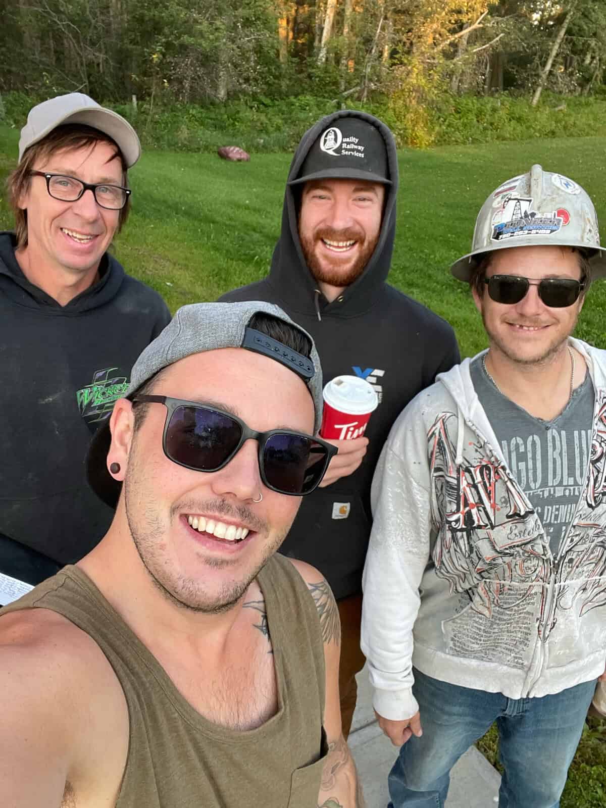 Group of friends posing outdoors with smiles.