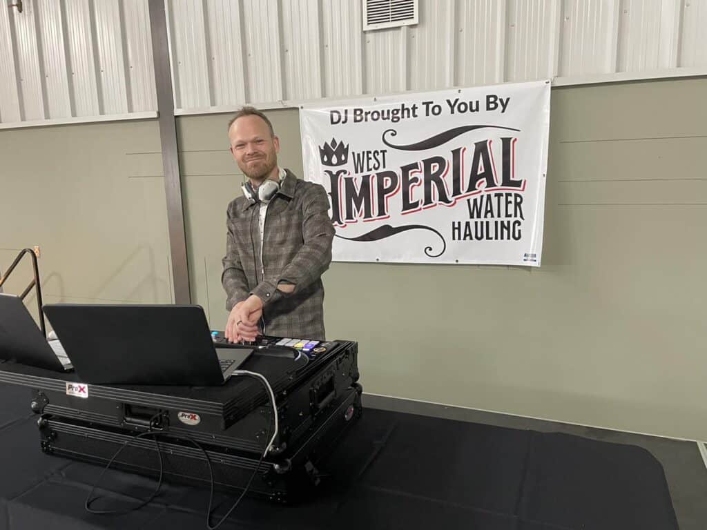 DJ performing at an event with equipment.