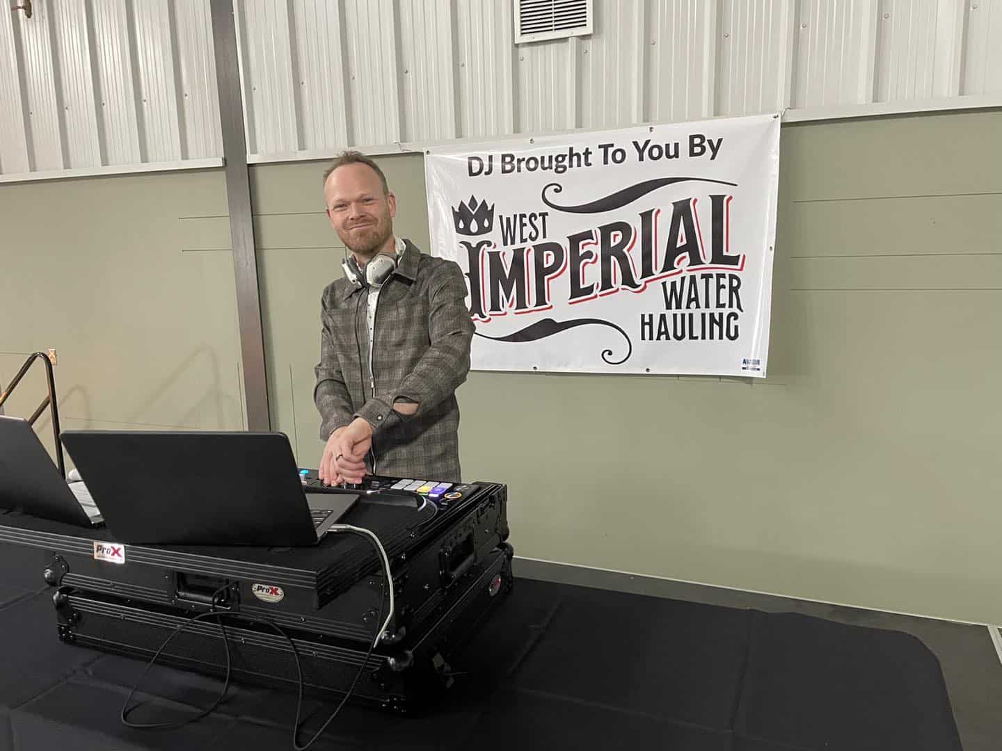 DJ performing at an event with equipment.